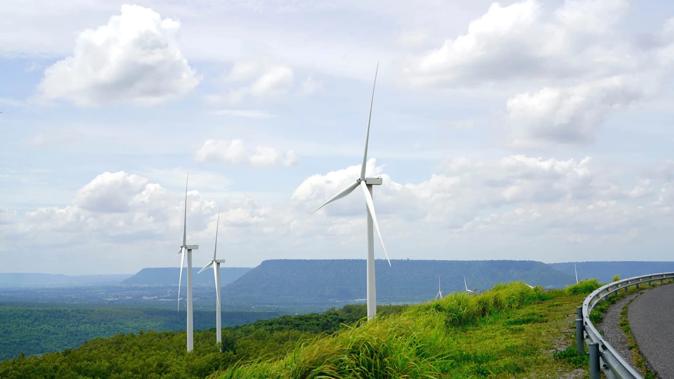 MaxUtility — wind turbines on a green hilltop